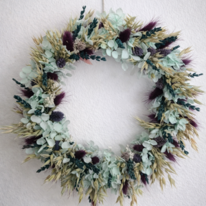Blumenkranz voll mit Trockenblumen bedeckt in Flieder, lila und türkis